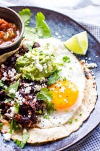 Huevos rancheros with a fried egg and beans on a plate.