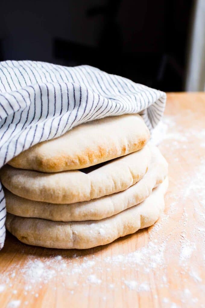 Four Sourdough Pitas stacked and wrapped in a tea towel.