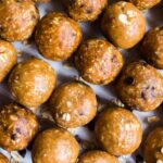 Close up of 3 ingredient peanut butter balls lined up on a sheet pan.