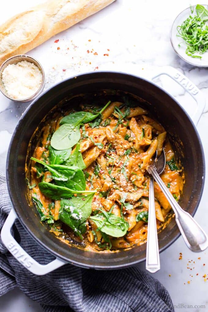 Creamy Vegetarian Pasta made in one pot with tomato mascarpone sauce in a Dutch oven garnished with spinach, basil and Parmesan cheese. 