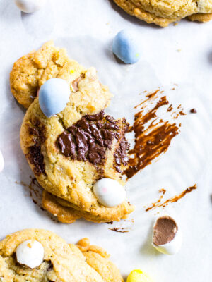 Half a Mini Egg Cookie on a sheet pan with a schmear of melted chocolate.