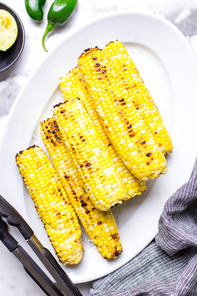 Grilled sweet corn on the cob on a serving platter.