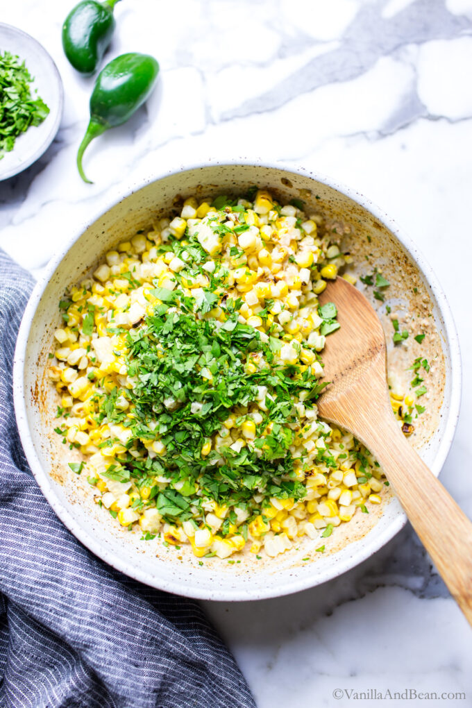 Grilled corn kernels in a bowl topped with cilantro.