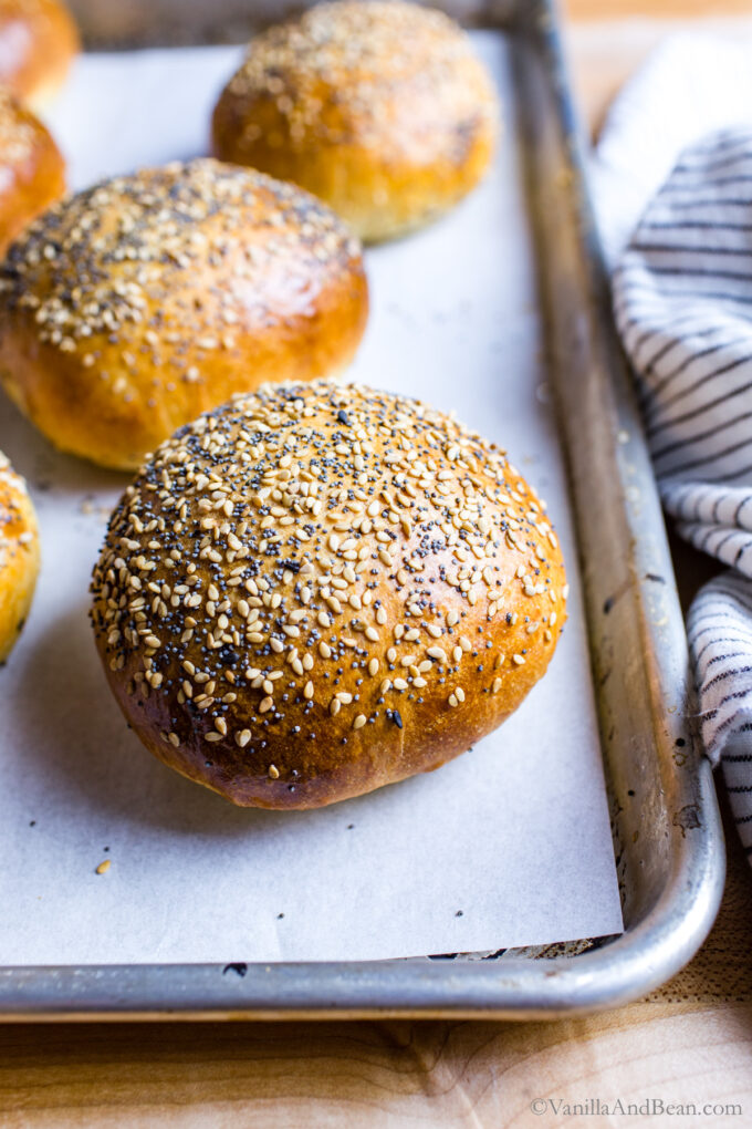 Close up of baked sourdough hamburger bun topped with sesame and poppy seeds.