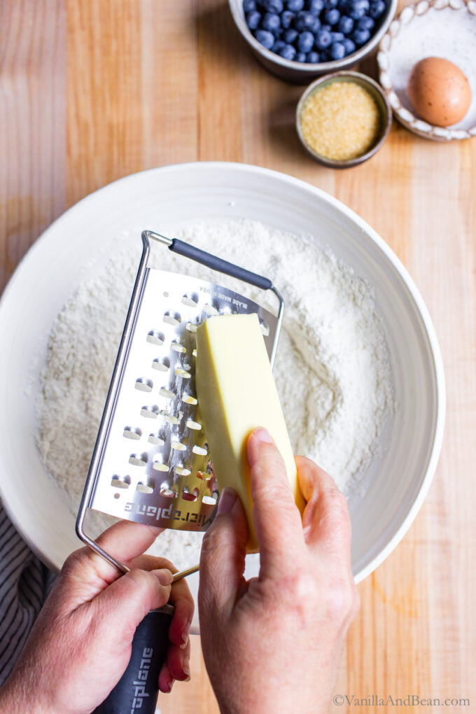 Grating butter into the dry ingredients.
