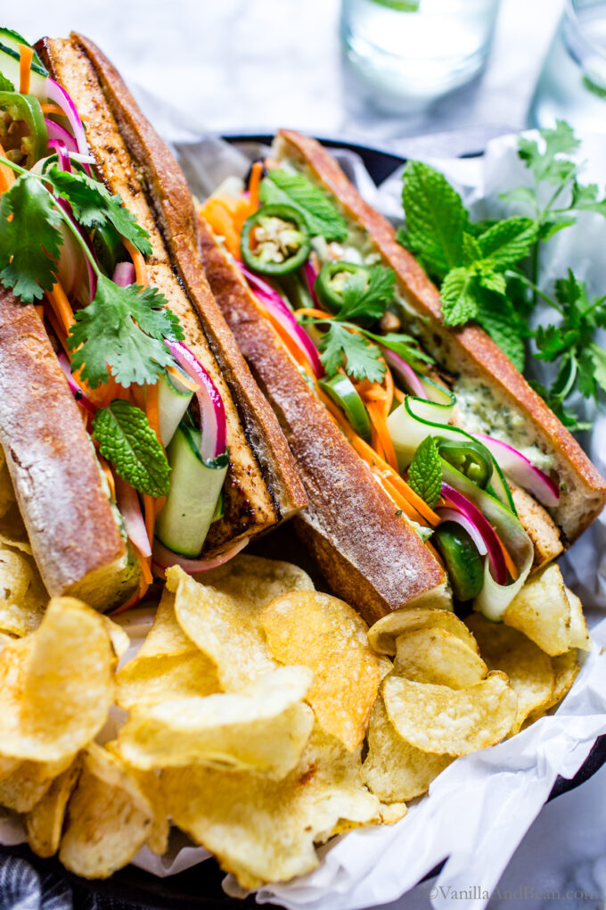 Vegetarian banh mi sandwiches with potato chips on the side.