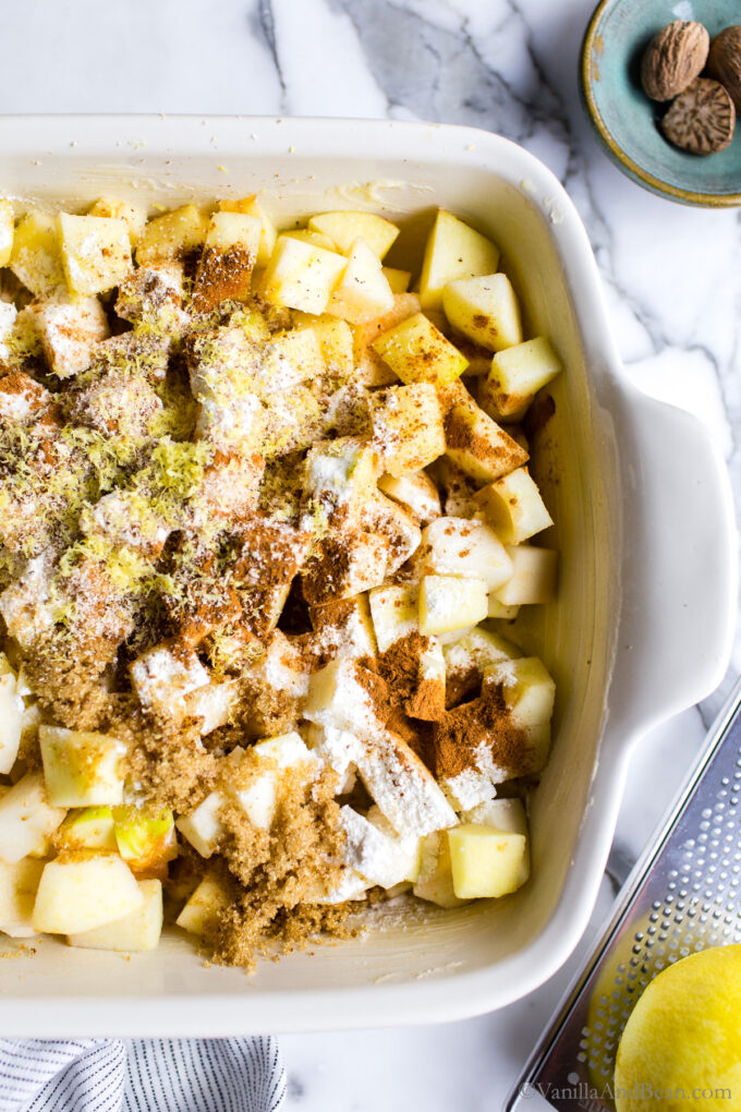 Diced apples in a baking pan with spices.