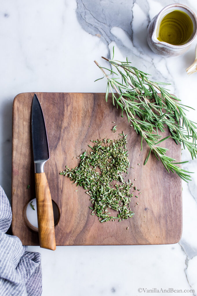 Minced rosemary on a cutting board.