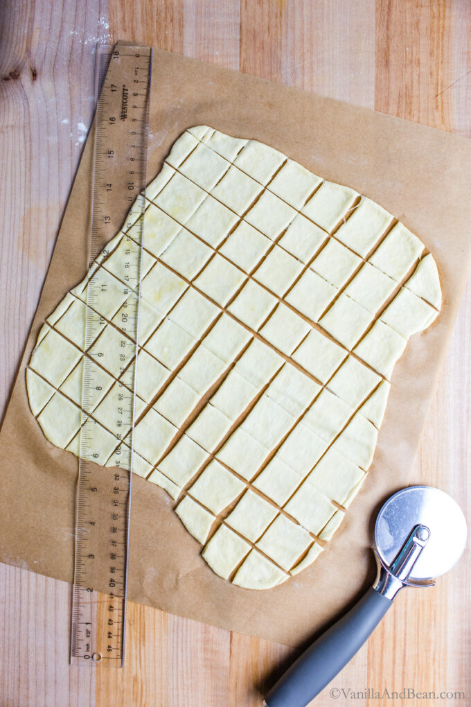 Cutting sourdough discard crackers with a pizza wheel.