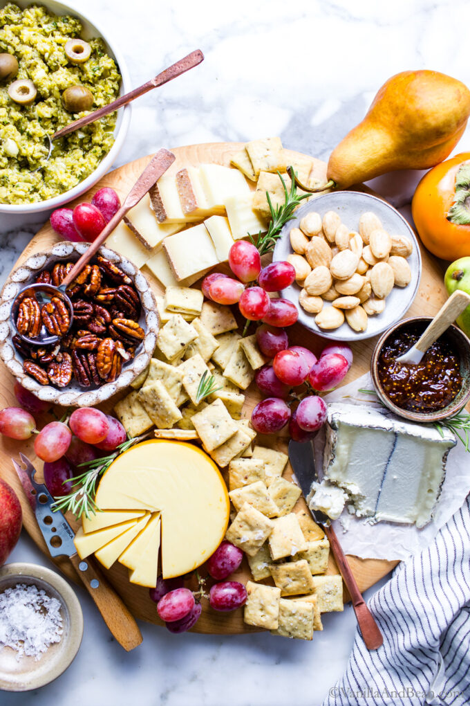 Cheese platter with sourdough crackers, grapes and nuts.