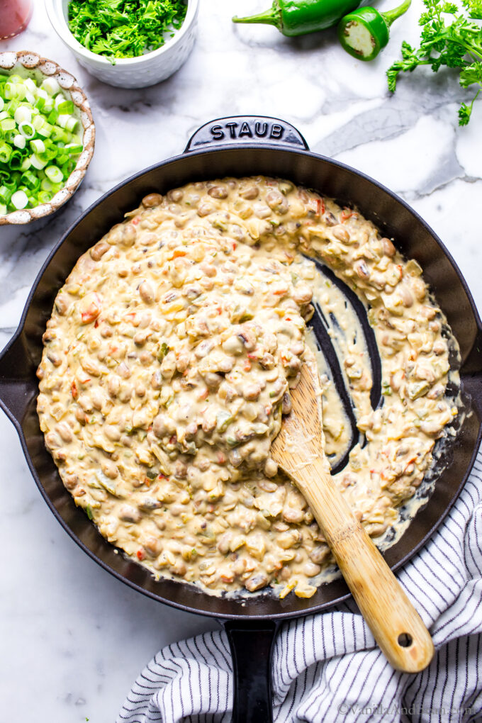 Creamy and warm Black Eyed Pea Dip with Cream Cheese in a skillet with a spoon in it.
