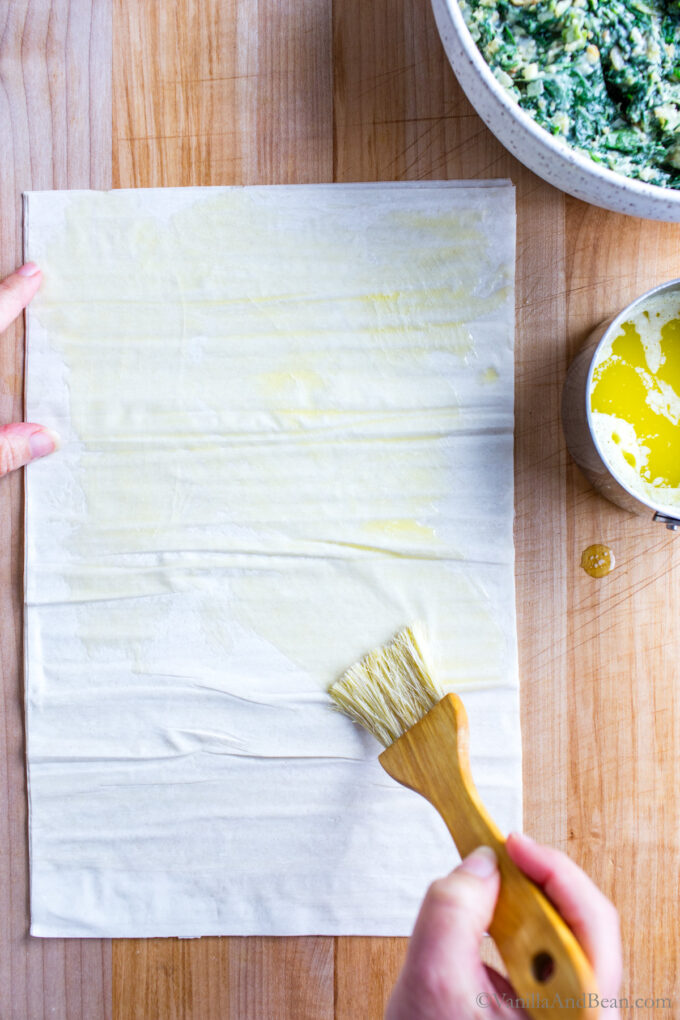 Brushing phyllo dough with melted butter.