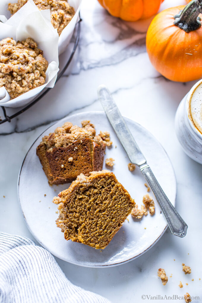 Cross section of a sourdough discard pumpkin muffin on a plate.