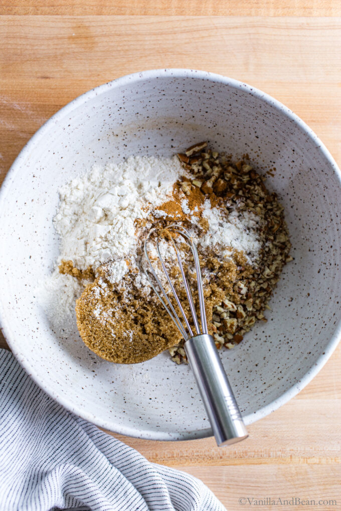 Whisking dry ingredients for the crumble streusel topping in a bowl.