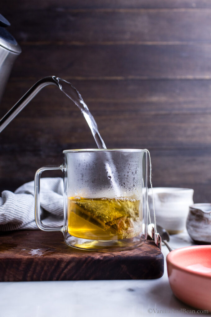 Pouring hot water into a cup with tea bags.