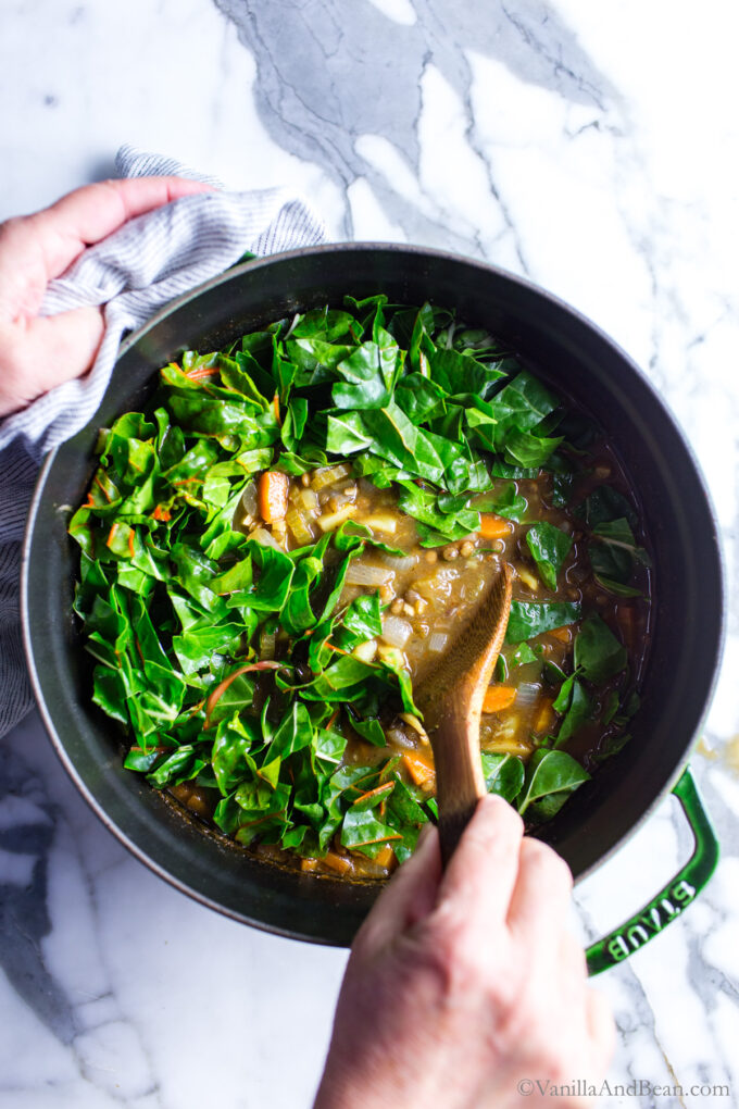 Adding Swiss chard to the lentil soup.