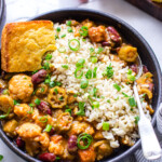 Veggie gumbo with okra in a bowl with a side of rice and cornbread.
