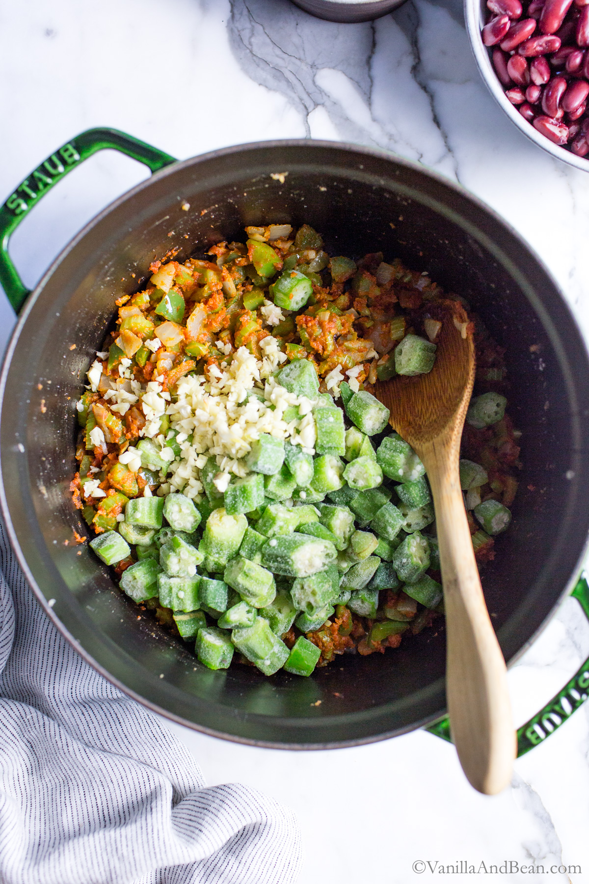 To the veggie gumbo pot, frozen okra and garlic is added.