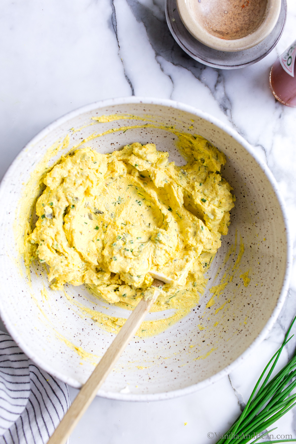 Hard cooked egg yolks in a bowl with other recipe ingredients stirred together.