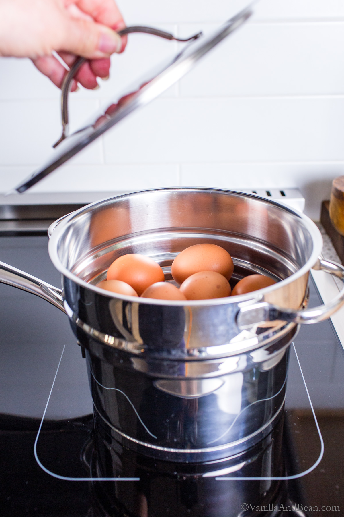 Fresh eggs in a double boiler steamer basket on the stovetop.