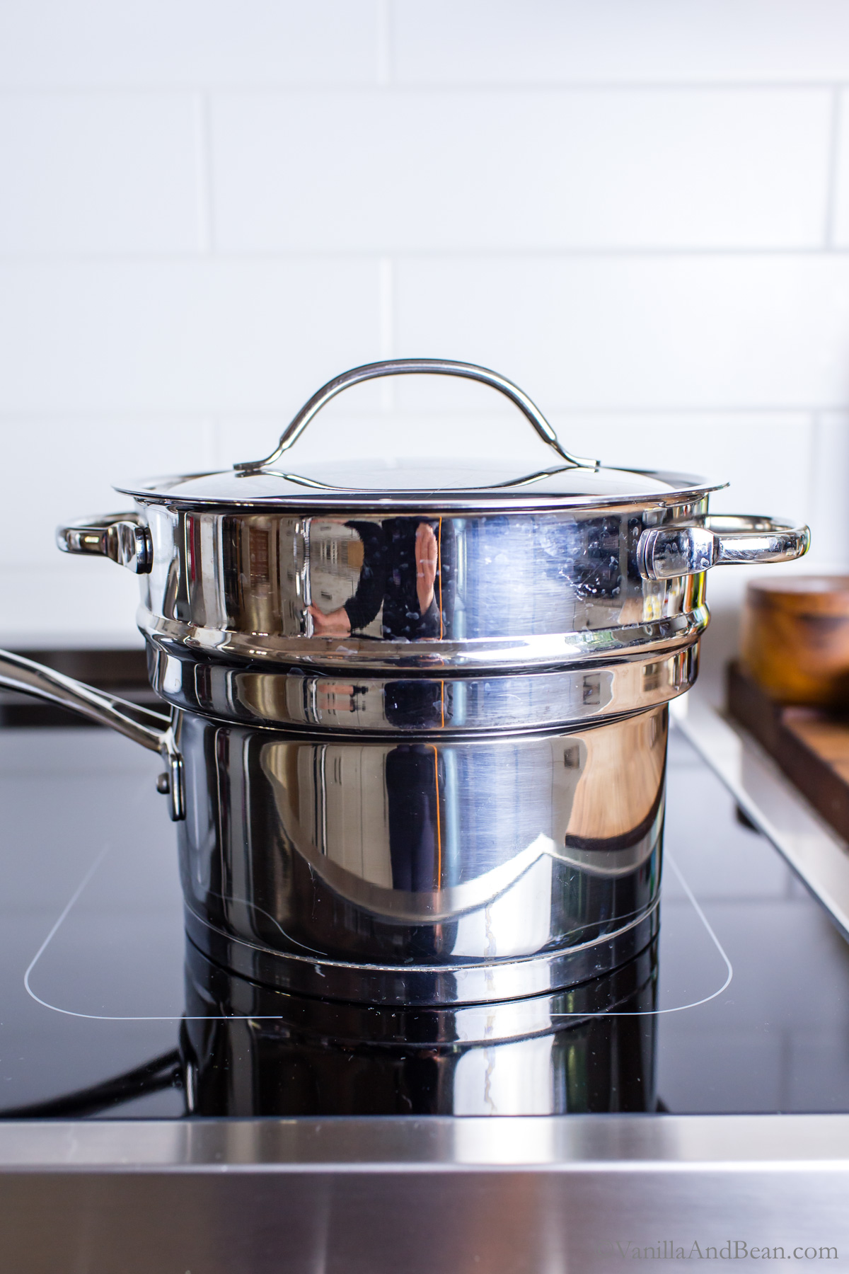 Double boiler fitted with a steamer basket on the stovetop.