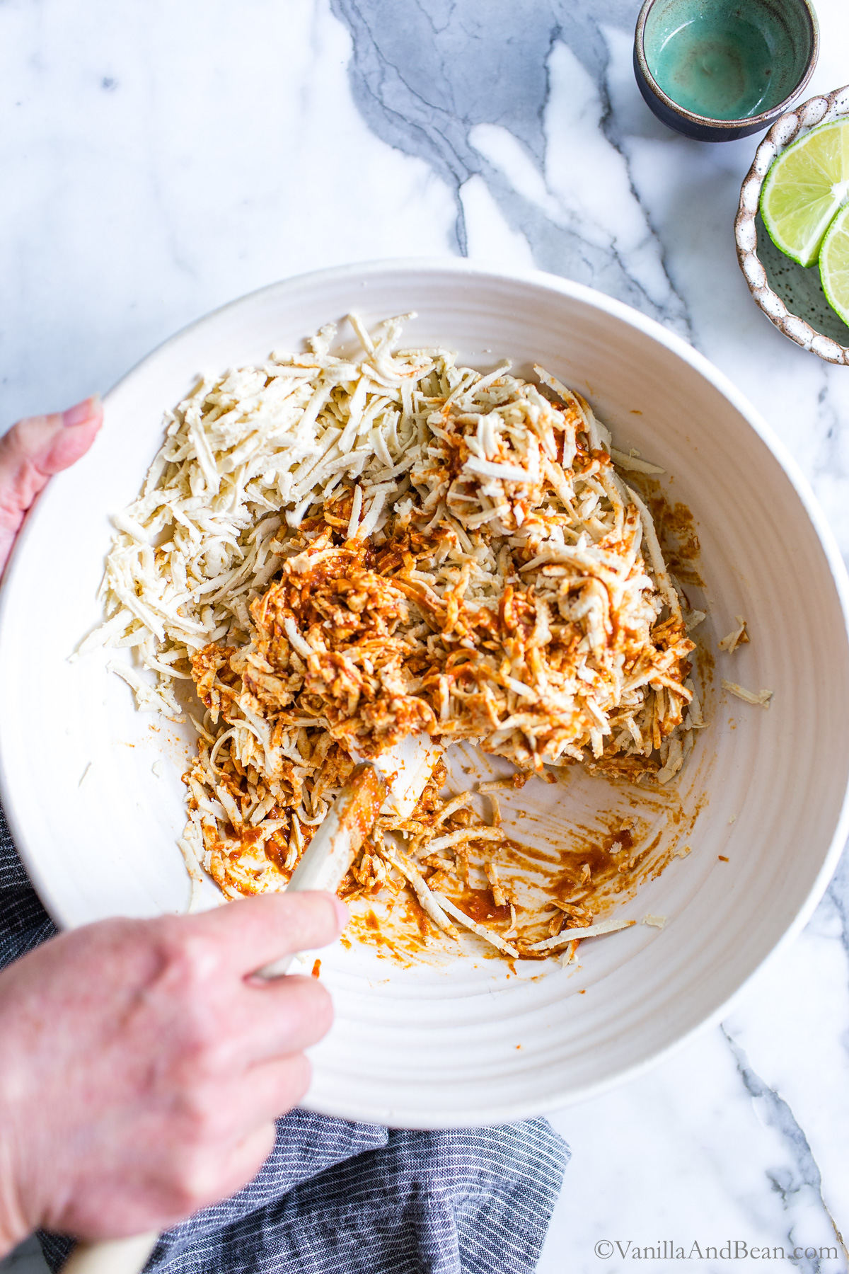 Mixing Tex Mex Shredded Tofu on a with seasonings in a bowl.