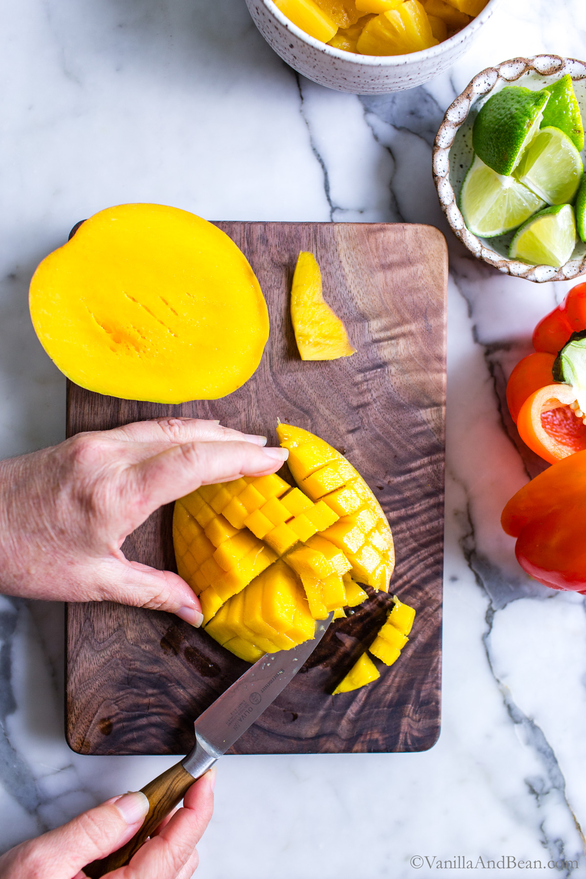 Dicing a mango on a cutting board.