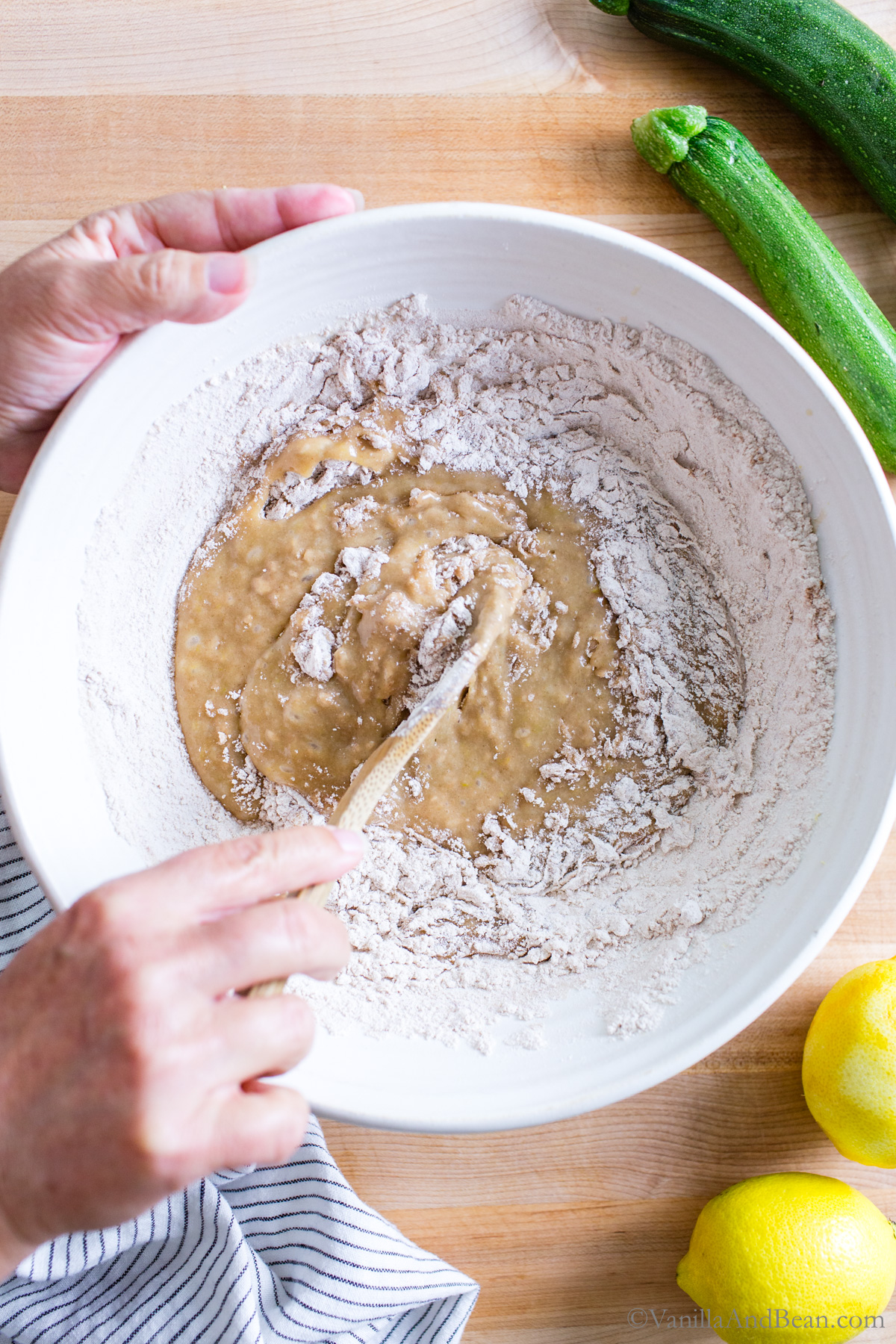 Flour mixture is added to the wet ingredients in a bowl.