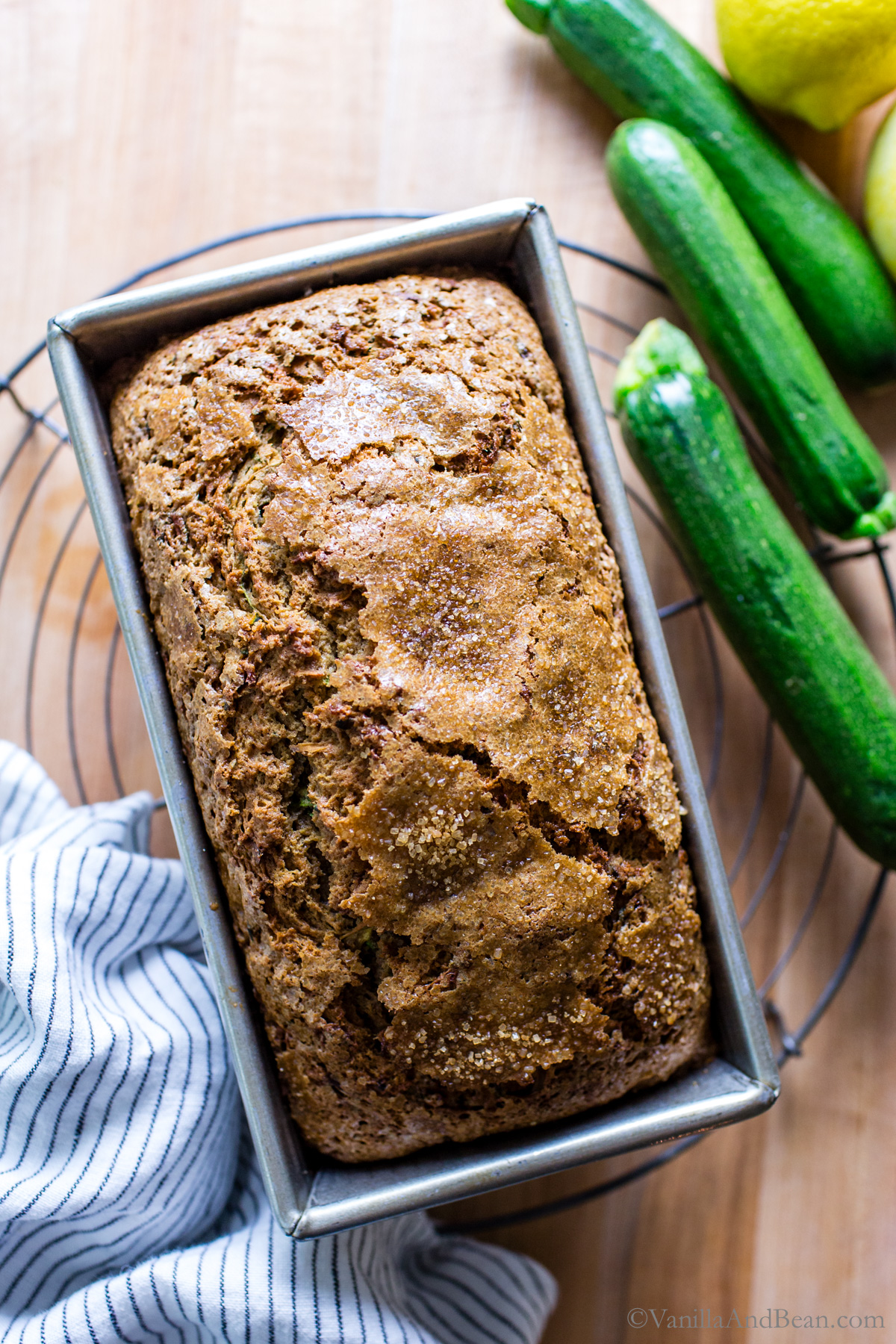 Baked sourdough zucchini bread on a cooling rack in a loaf pan.