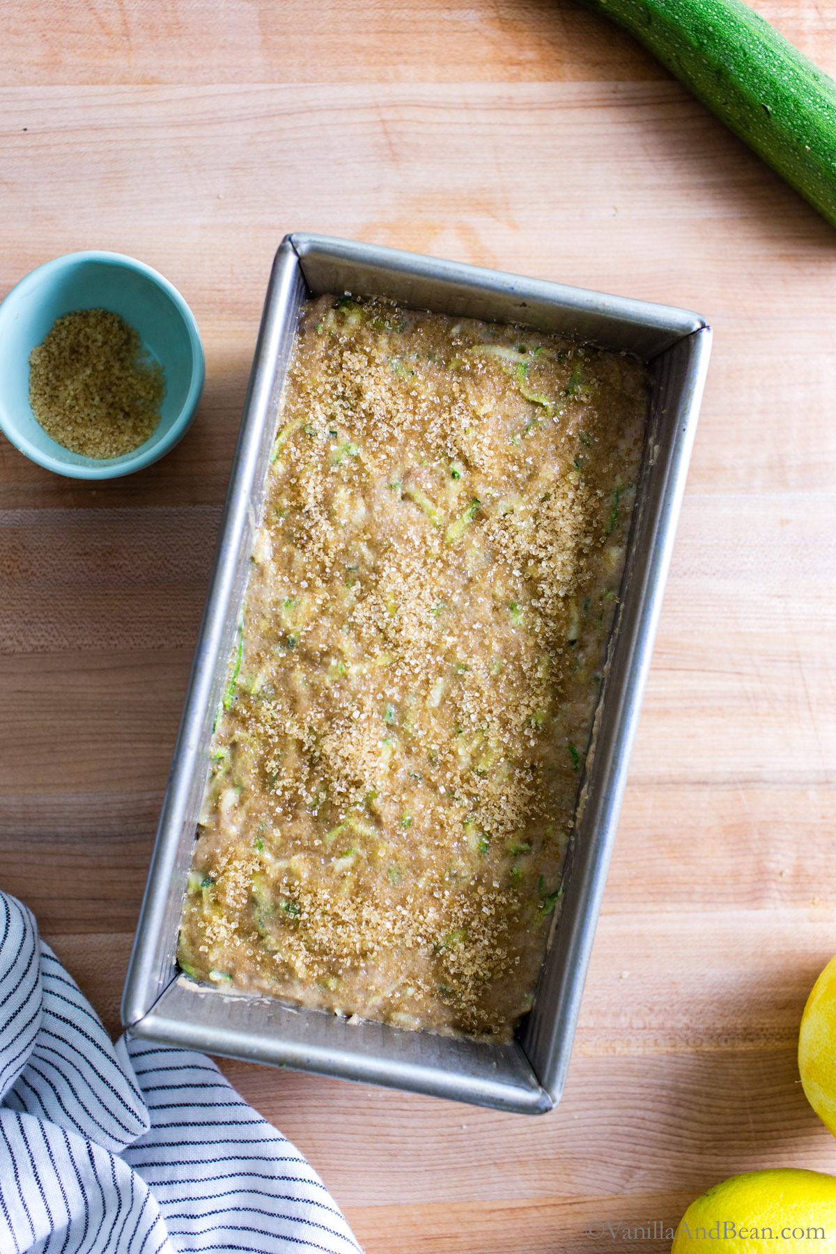 Smoothed zucchini batter in a loaf pan with raw sugar sprinkled on top.