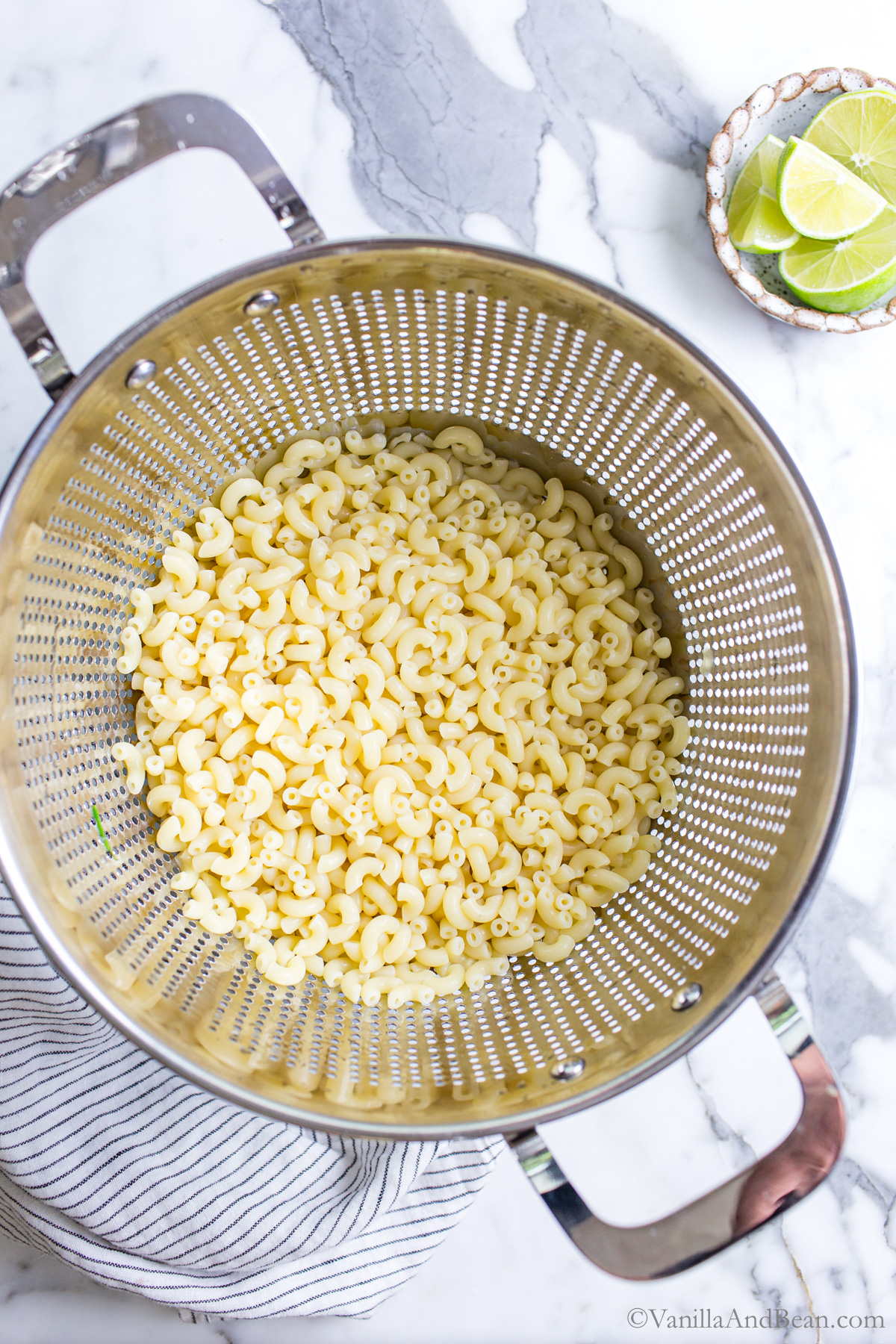 Macaroni pasta drained in a strainer.
