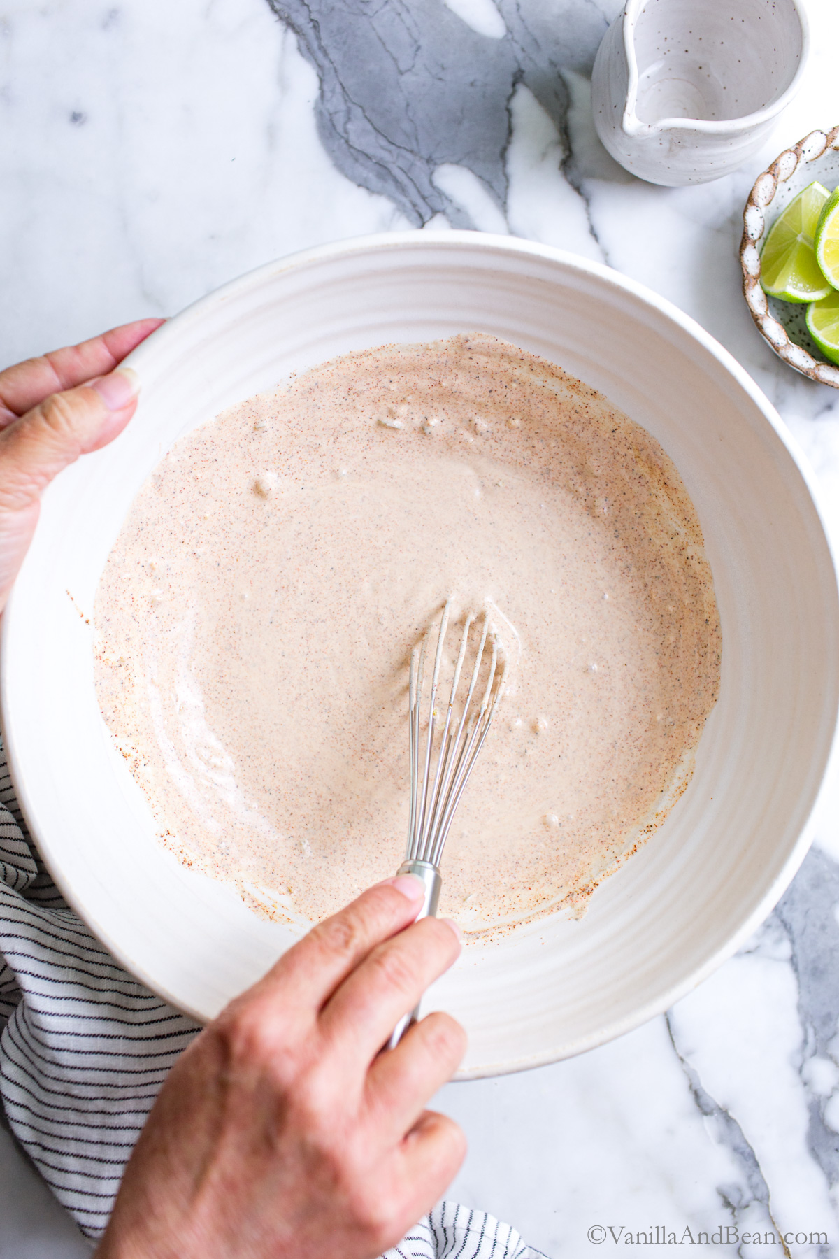 Street corn mayo dressing being whisked in a large bowl.