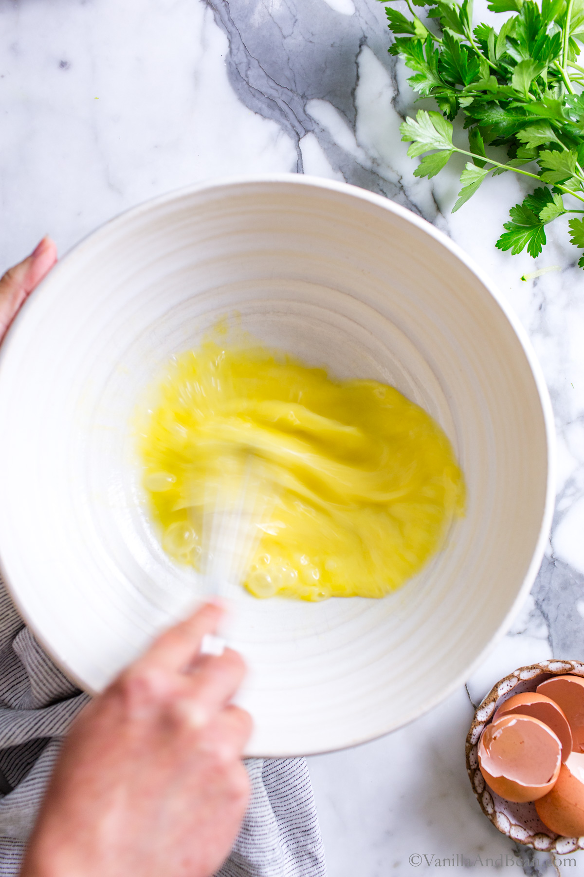 Whisking eggs in a large mixing bowl.