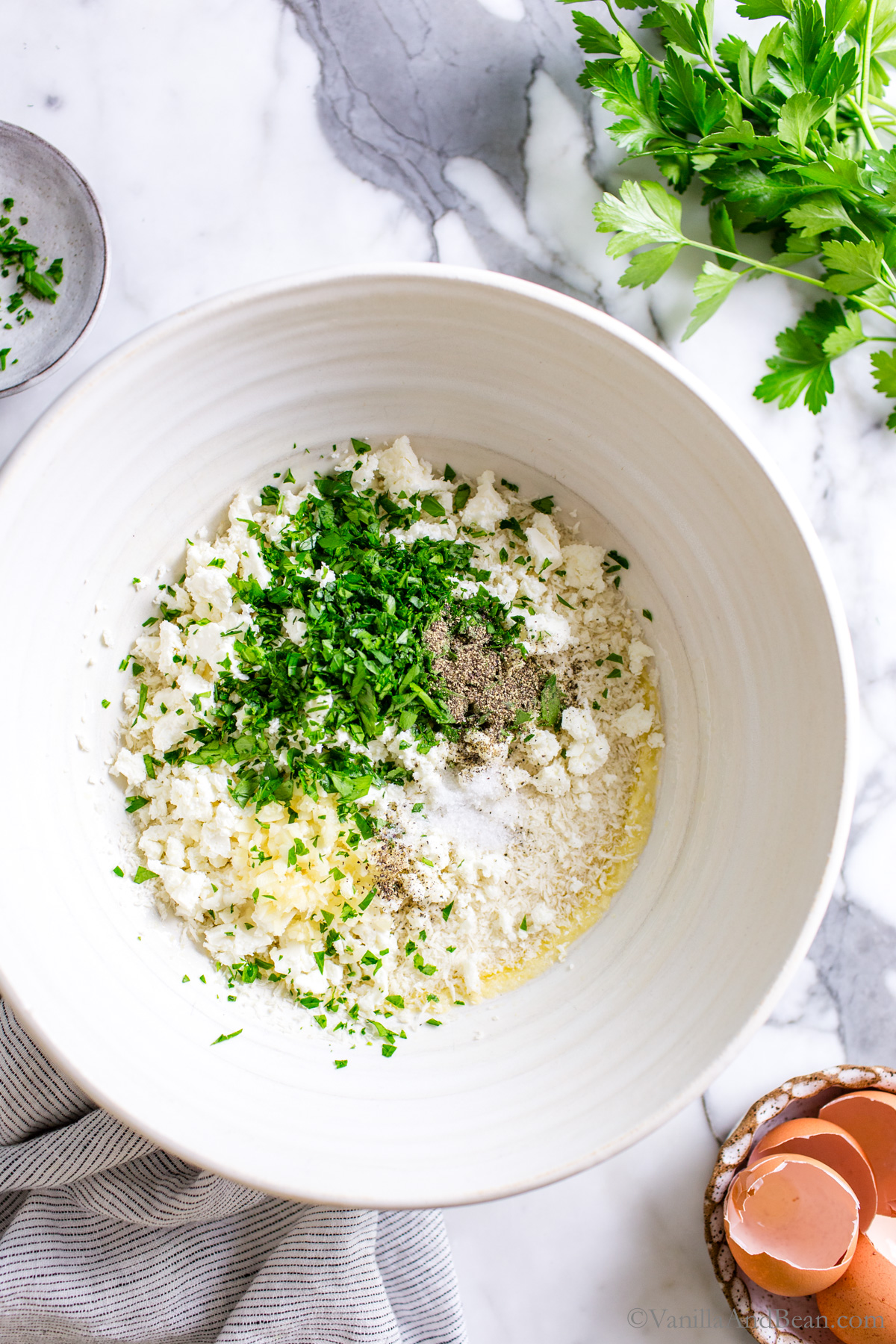 Zucchini and Feta fritter ingredients in a large mixing bowl.