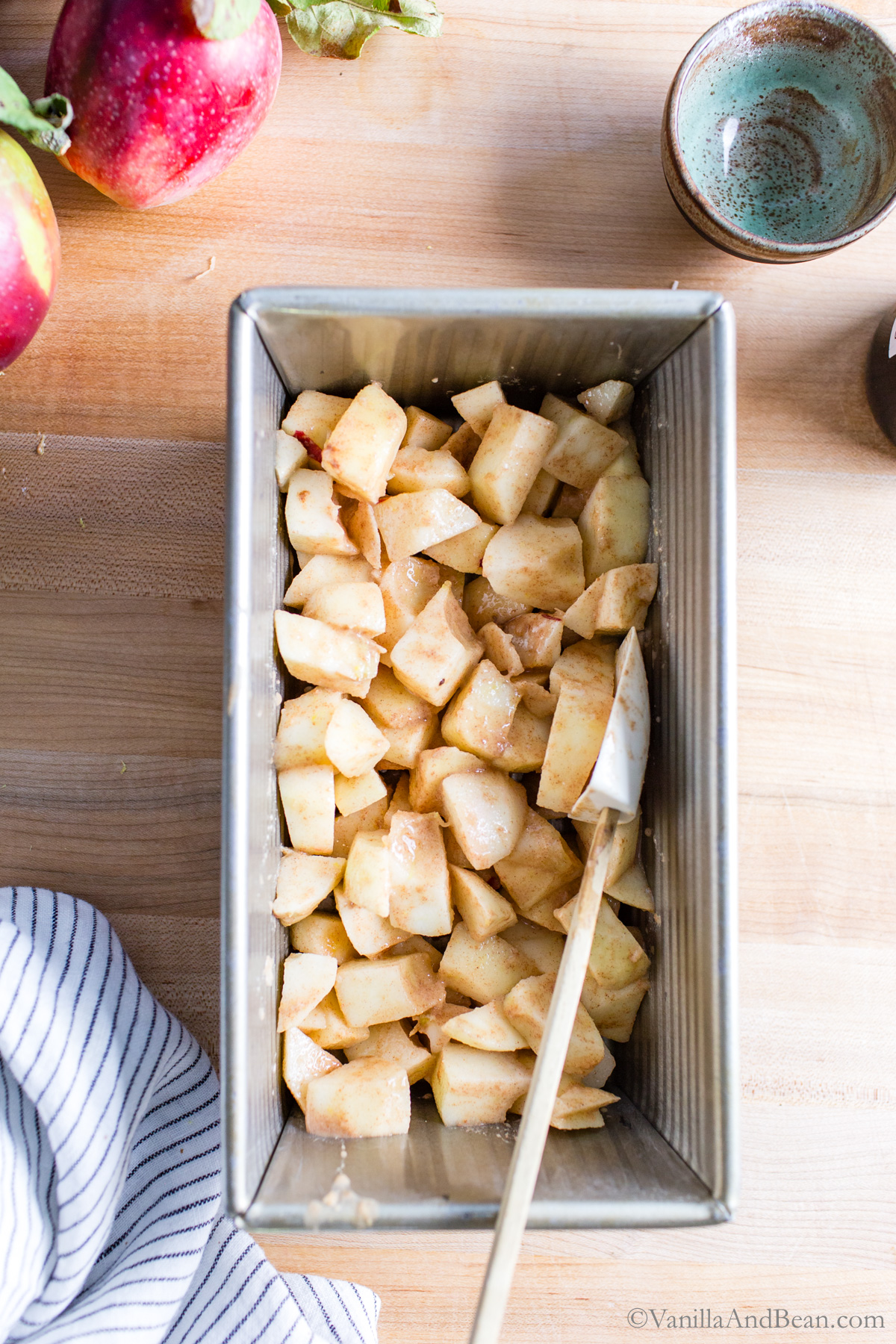 Spiced apples in a buttered loaf pan.