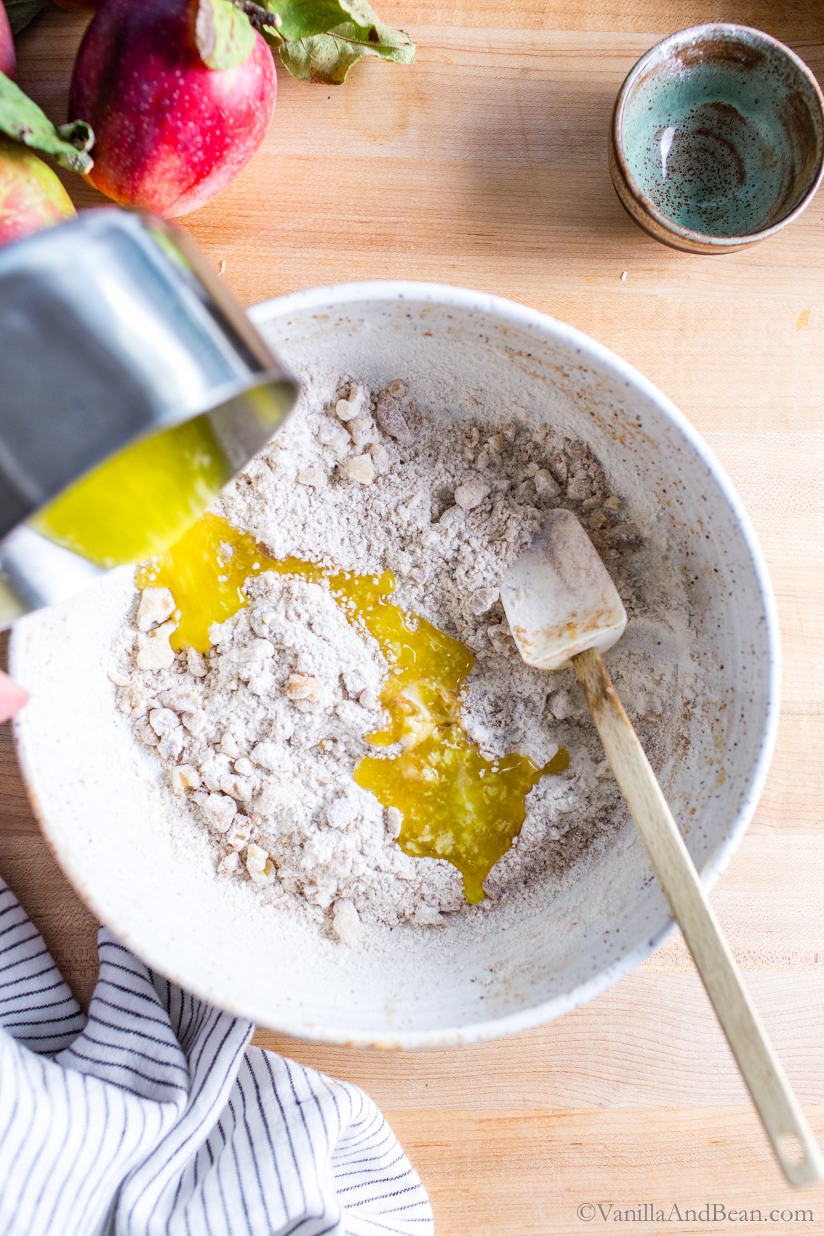 Melted butter poured into a bowl of dry ingredients.